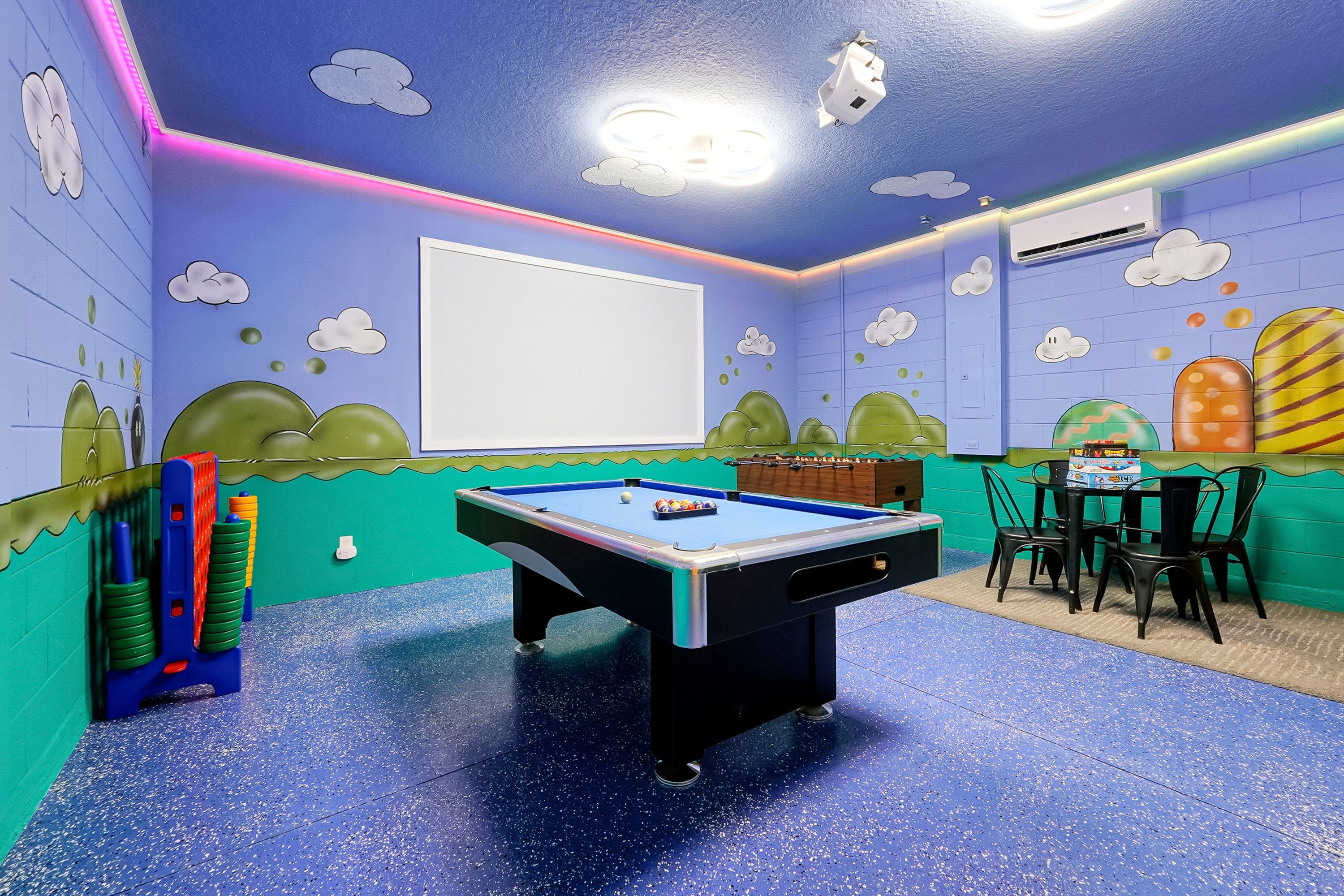 A room with a pool table, chairs, and a foosball table.