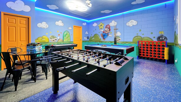 A room with a foosball table, a pool table, and a Nintendo-themed mural. - All the best family comforts at this very popular 5 bedroom home (Davenport)