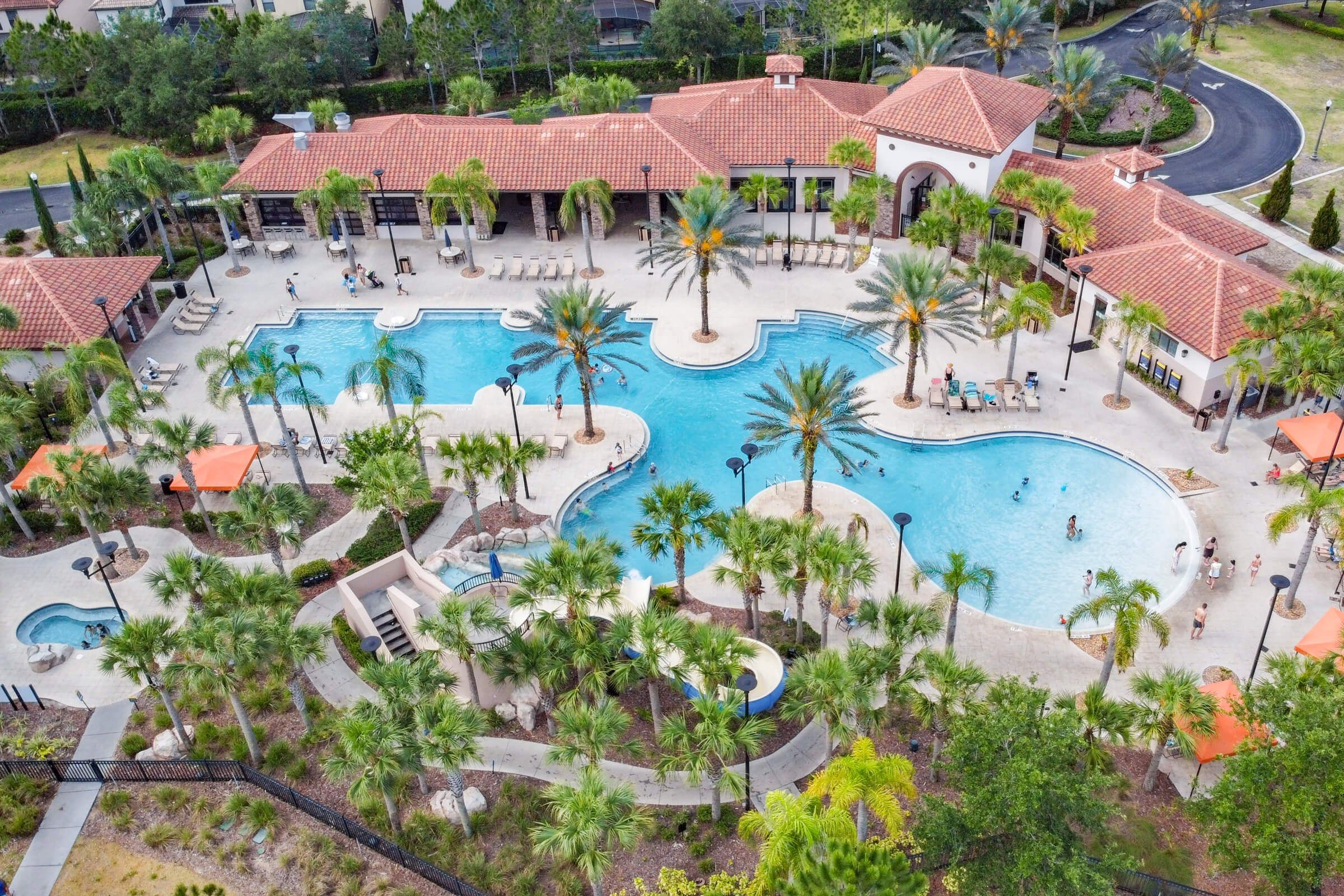 Un resort con múltiples piscinas, palmeras y zonas de descanso.
