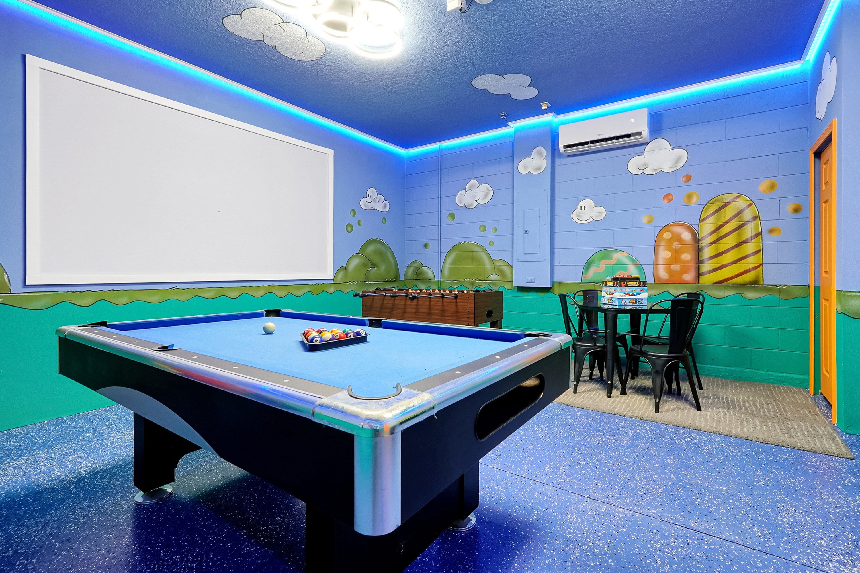 Une pièce équipée d’une table de billard, de chaises et d’une table de baby-foot.