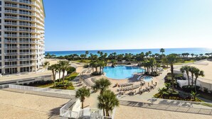 Ein Resort mit großem Pool, Palmen und Meerblick.