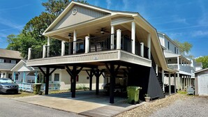 A two-story house with a covered porch and a garage. - Beautiful Ocean Lakes site O26!  Limo cart included! Small pet friendly! (Myrtle Beach)