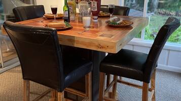 Een eettafel met stoelen, een spiegel en verschillende soorten eten.