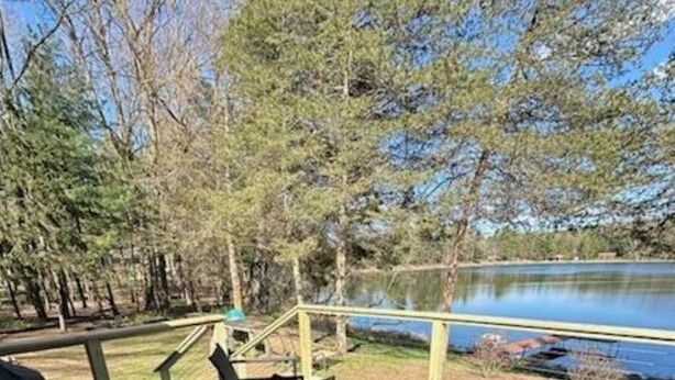 Eine Terrasse mit Sitzgelegenheiten im Freien mit Blick auf einen See, umgeben von Bäumen.