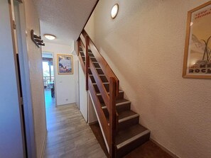 A staircase with wooden handrails and a landing area with a framed picture.
