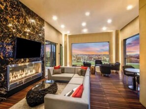 Relax by the fireplace in this stylish living room with a city view.
