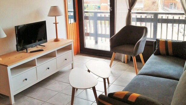 A living room with a television, a small table, a sofa, and a chair. - 100m from ski slopes, 3rd floor, balcony, tv, ski locker, 42m², Les 2 Alpes (Les Deux Alpes)