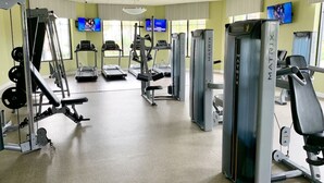 Academia com esteiras, aparelhos de musculação e equipamentos de cardio.