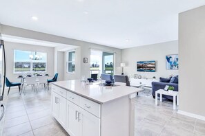 Relax in this open-plan living space with a central kitchen island and comfortable seating area.