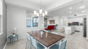 A modern kitchen with white cabinets, a black countertop, and a stainless steel refrigerator. - 3191-106 Resort Lake View Disney Universal Orlando (Kissimmee)