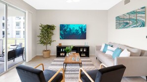 A modern living room with a sofa, coffee table, and a large abstract painting. - 3150-106 Resort Pool View Disney Universal Orlando (Kissimmee)