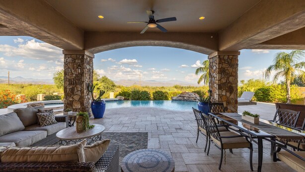 A covered outdoor patio with a pool, stone pillars, and outdoor furniture. - Luxury Hideout with Infinity Pool & Spa (Scottsdale)
