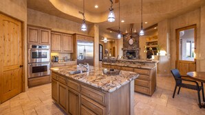 A spacious kitchen with granite countertops, wooden cabinets, and stainless steel appliances. - Luxury Hideout with Infinity Pool & Spa (Scottsdale)