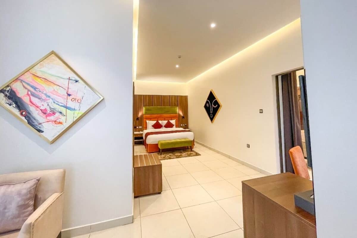 A modern hotel room with a bed, a desk, and a chair.