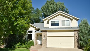 A two-story house with a garage, a front door, and a small front yard with a lawn and a tree. - Bright & Spacious 3 Bedroom Home in Coveted Loveland Neighborhood! (Loveland)