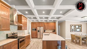 A modern kitchen with wooden cabinets, stainless steel appliances, and a central island.