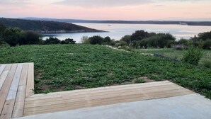 Eine Terrasse mit Blick auf einen See und eine entfernte Hügellandschaft.