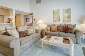 Ein Wohnzimmer mit zwei Sofas, einem Couchtisch und Wandbildern.
