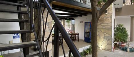 A staircase with a metal railing leading to a balcony.