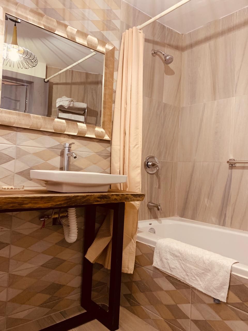 Un baño con lavamanos, espejo, ducha y bañera.