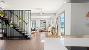 A modern interior with a staircase, a dining area, and a view of the outdoors.