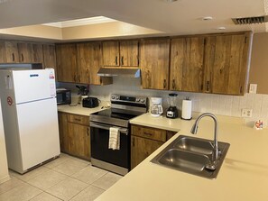 Una cocina moderna con armarios de madera, electrodomésticos de acero inoxidable y un lavamanos doble.