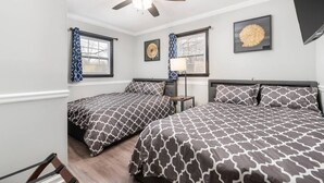 A bedroom with two beds, a ceiling fan, and a window with curtains. - "Crowder's Cottage" — Cozy retreat near Kings Mountain & Gastonia, NC (Gastonia)