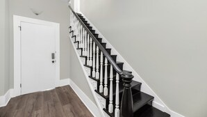 Una escalera con balaustres negros y paredes blancas.