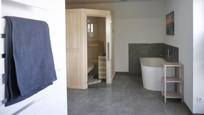 Een moderne badkamer met een douche, toilet en wastafel.
