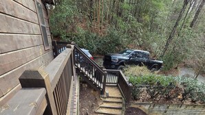 A wooden deck with a metal railing, a wooden staircase, and a vehicle parked nearby. - Twin Fox Cabin Peaceful Blue Ridge/Ellijay Retreat (Cherry Log)