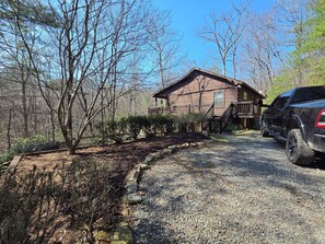 A rustic cabin with a gravel driveway, surrounded by trees and a parked SUV. - Twin Fox Cabin Peaceful Blue Ridge/Ellijay Retreat (Cherry Log)