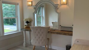 Une pièce avec un grand miroir, une chaise et une fenêtre.