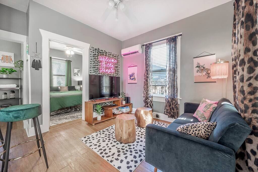 A modern living room with a sofa, a TV, a coffee table, and a wooden floor.
