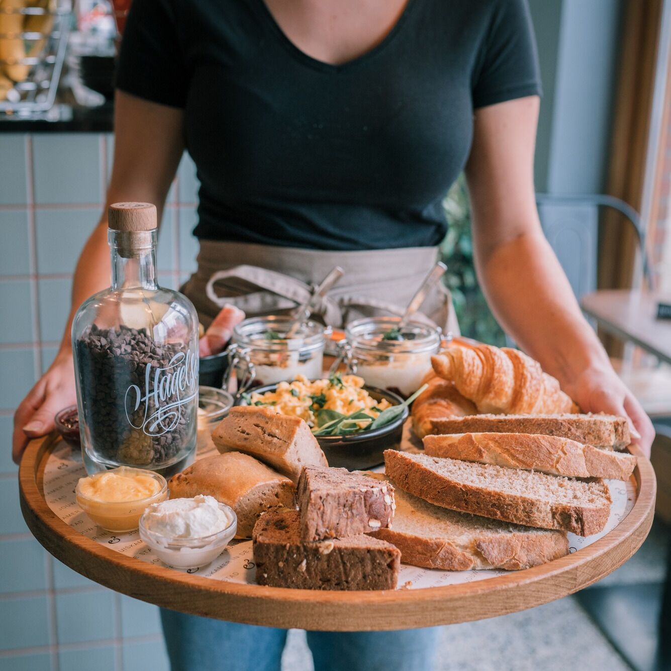 A tray with various food items including bread, pastries, and condiments.