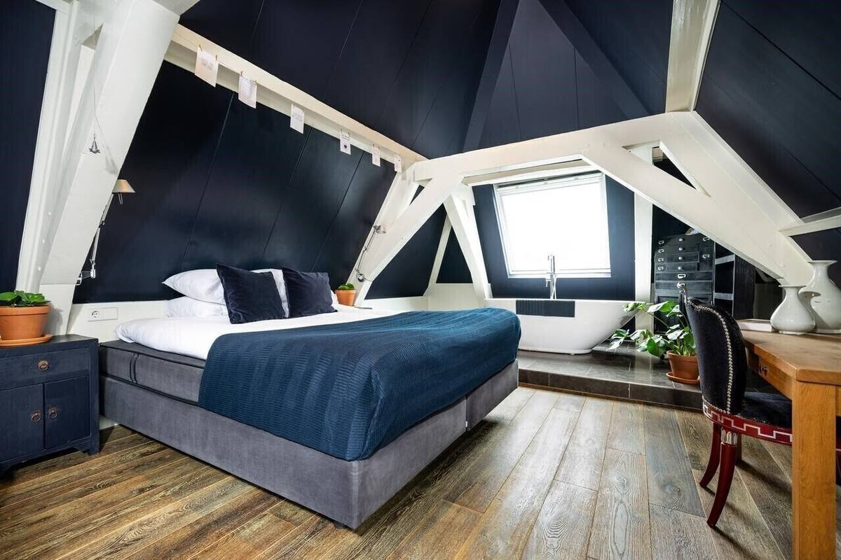 A bedroom with a bed, bedside table, and a window.