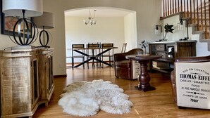 Ein geräumiges Wohnzimmer mit einem Holzespeisetisch, einem weißen, flauschigen Teppich und einem Holzschrank.