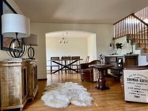 Cozy living space with a dining table, chandelier, and staircase.