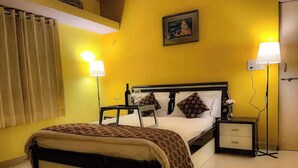A bedroom with a bed, bedside tables, lamps, and a painting on the wall.