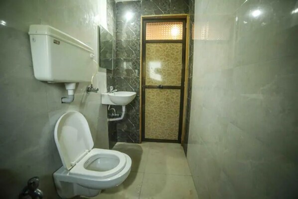 Bathroom features a toilet, sink, and tiled floor.