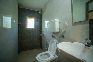 Bathroom features a toilet, sink, and water storage tank.