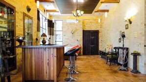 A rustic bar area with a wooden counter, bar stools, and a tiled floor. - LSQ RJ FARMS 3BHK VILLA WITH PRIVATE POOL! (Karjat)