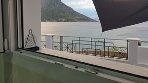 A balcony with a view of a calm lake and a mountain.