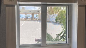 Ein Fenster mit Blick auf einen Parkplatz und eine Tankstelle.
