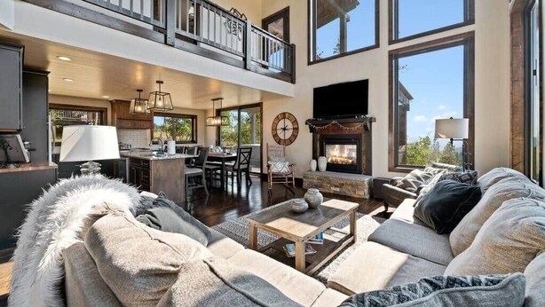 A spacious living room with a fireplace, a dining area, and a kitchen. - Altitude Adjustment (Lead)