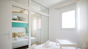 Een moderne hotelkamer met een groot bed, een klein tafeltje en een raam met gordijnen.