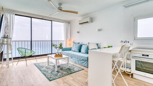 Een moderne woonkamer met een bank, een eettafel en een keukenhoek.