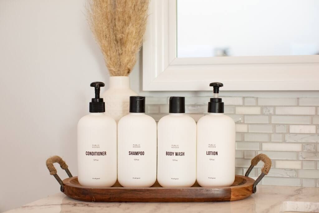 Four bottles of personal care products on a wooden tray.