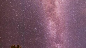 A small building with a red exterior and a clear view of the Milky Way.