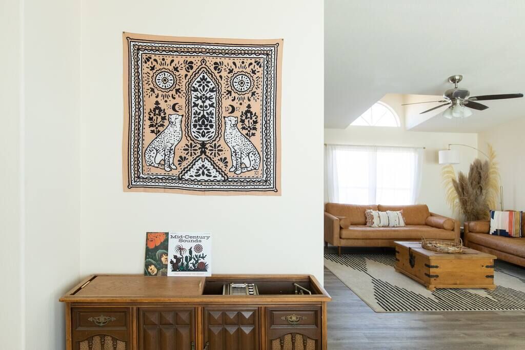 A living room with a brown sofa, a wooden coffee table, and a ceiling fan.
