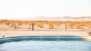 Una piscina con un paisaje desértico al fondo.